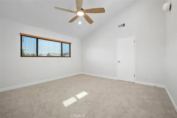 an empty room with a window and a fan