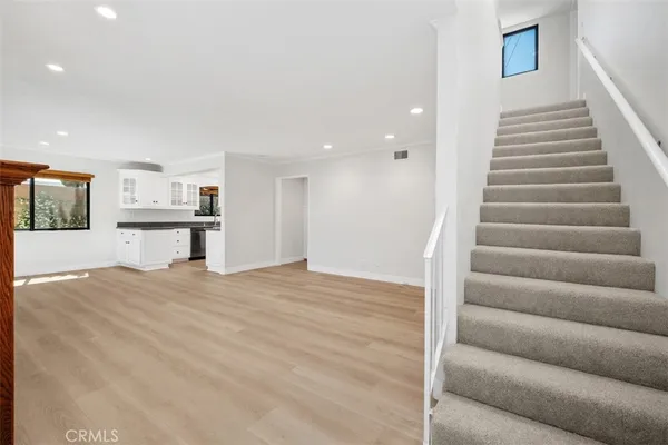 a view of a livingroom with wooden floor and stairs