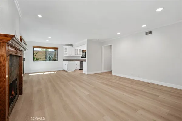 a view of empty room with a fireplace and wooden floor