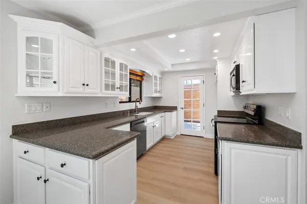 a kitchen with granite countertop a sink a stove and cabinets