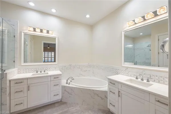 a bathroom with a granite countertop sink mirror and bathtub
