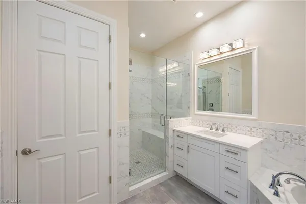a bathroom with a double vanity sink mirror and bathtub