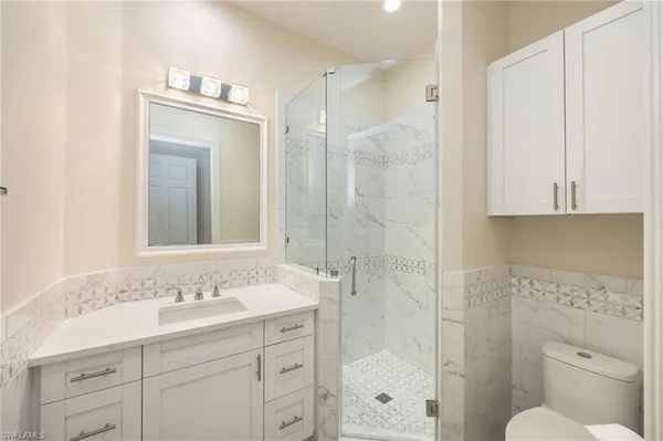 a bathroom with a shower sink vanity and mirror