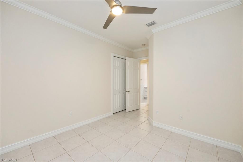 5025 Maxwell Circle, Unit 2 Naples, FL 34105 - Photo 18 of 24 an empty room with a ceiling fan and carpet