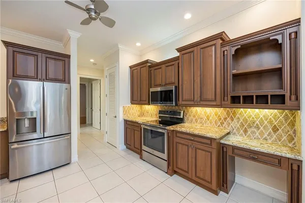 a kitchen with stainless steel appliances granite countertop a refrigerator a stove and a sink