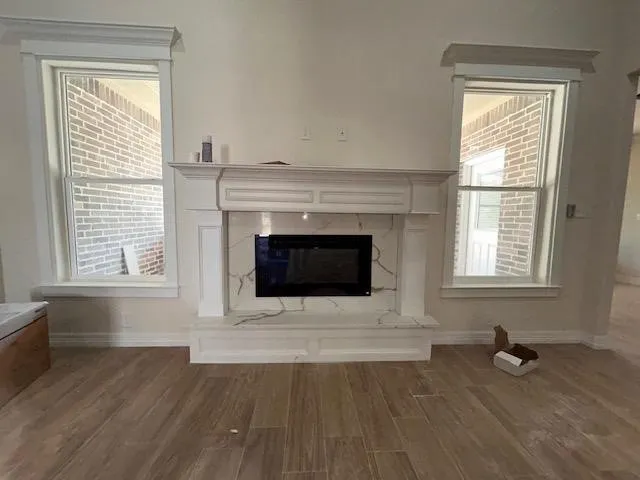 an empty room with wooden floor and fireplace