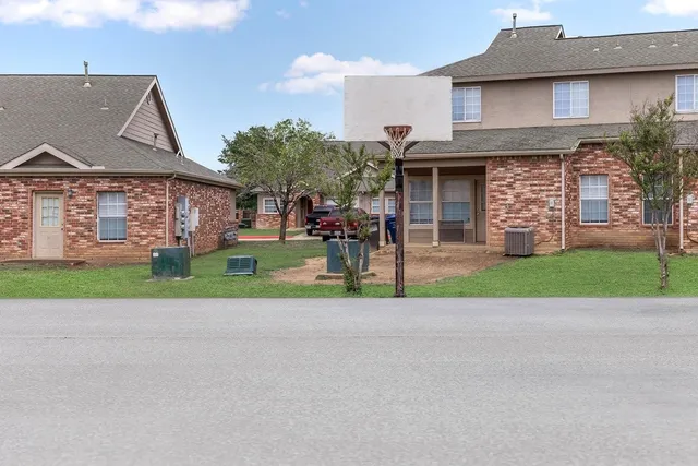 a view of a house with a yard and large tree