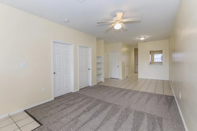 wooden floor in an empty room with a ceiling fan