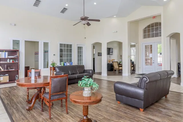 a living room with furniture kitchen and a chandelier