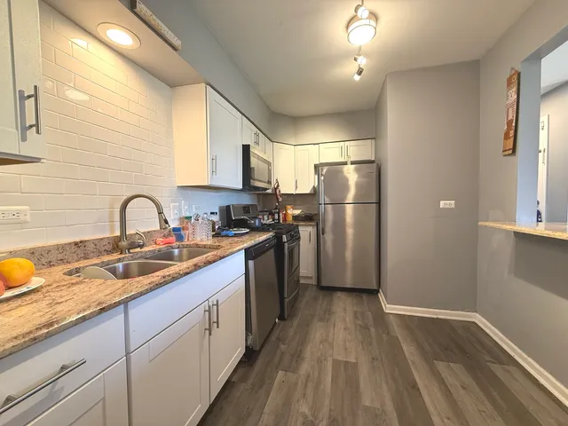 a kitchen with stainless steel appliances granite countertop a sink stove and refrigerator
