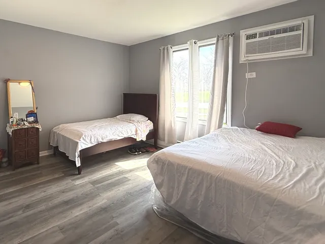 a bedroom with two beds and a night stand