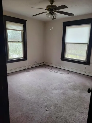 an empty room with a window and a ceiling fan