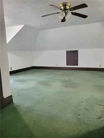 a view of a room with a ceiling fan and hardwood floor