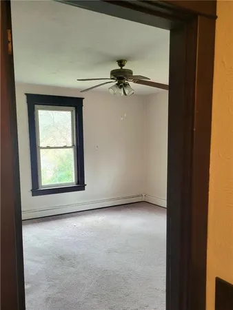 an empty room with windows and fan