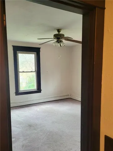 an empty room with windows and fan
