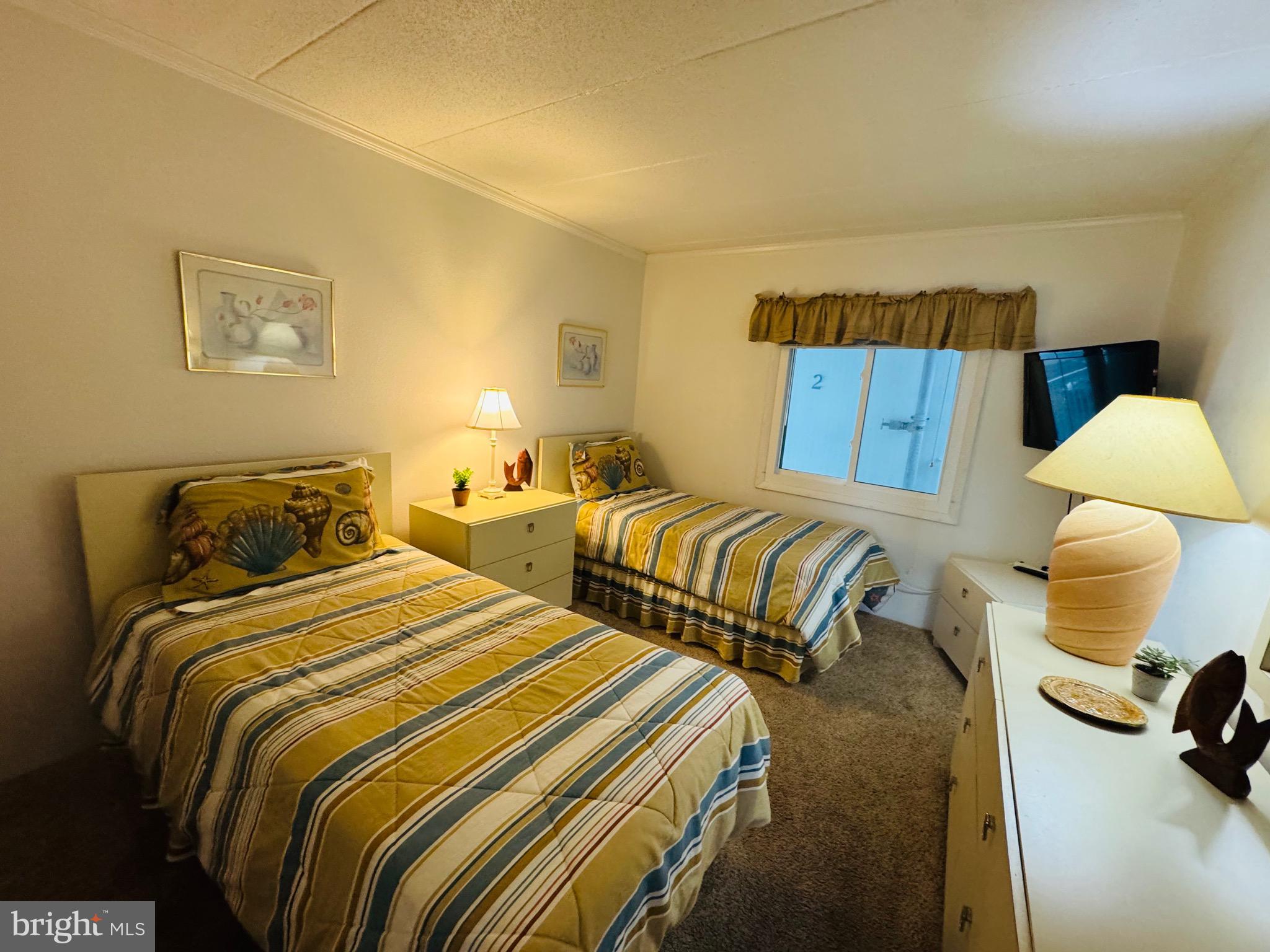 2 80th Street, Unit 212 Ocean City, MD 21842 - Photo 18 of 27 a bedroom with two beds and painting on the wall