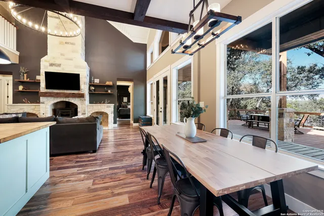 a kitchen with stainless steel appliances a dining table chairs and wooden floor