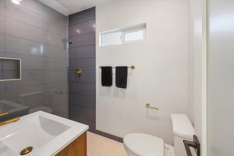 a bathroom with a double vanity sink toilet and shower
