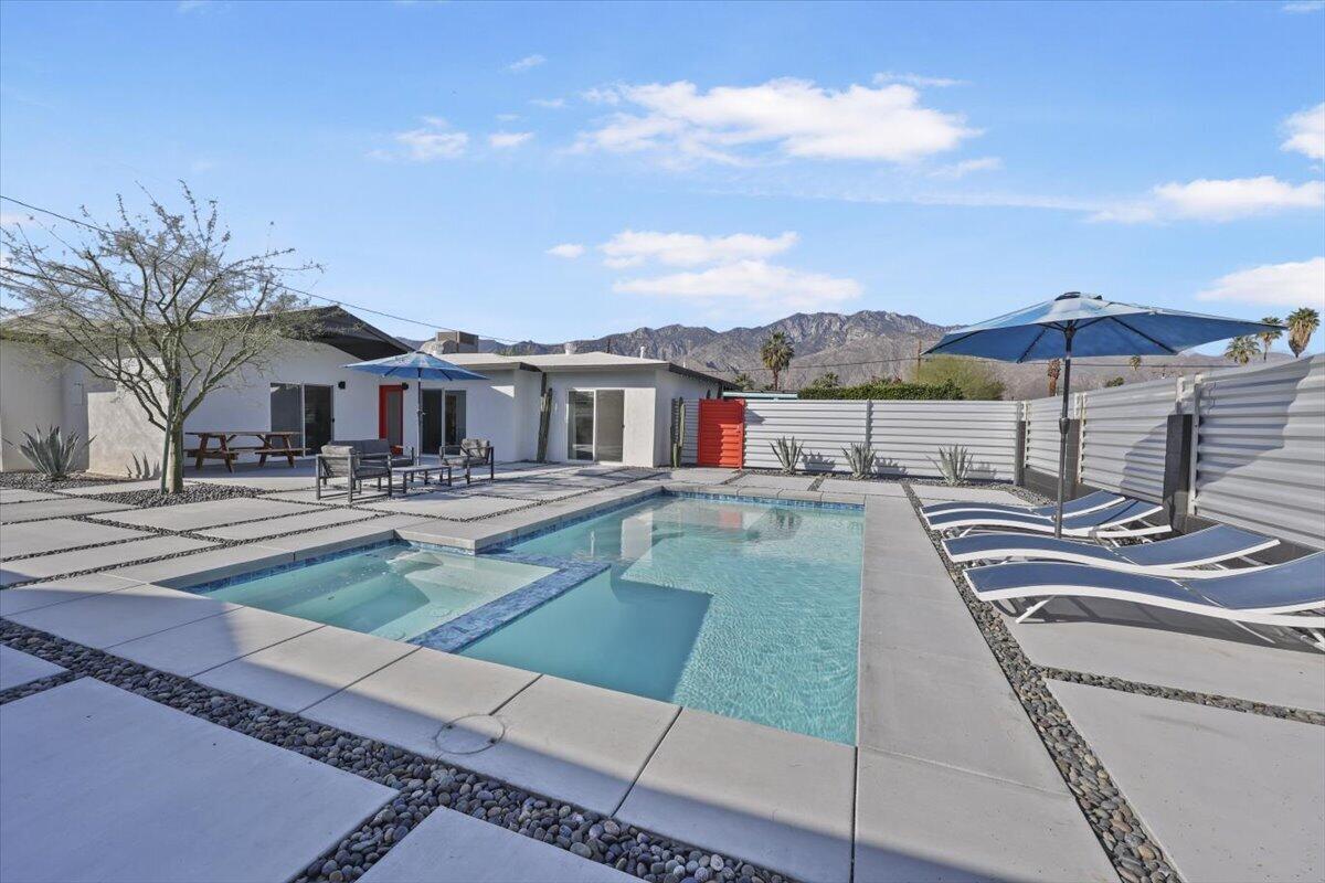 3991 Calle San Raphael Palm Springs, CA 92264 - Photo 2 of 45 a view of a patio with couches and a table and chairs under an umbrella
