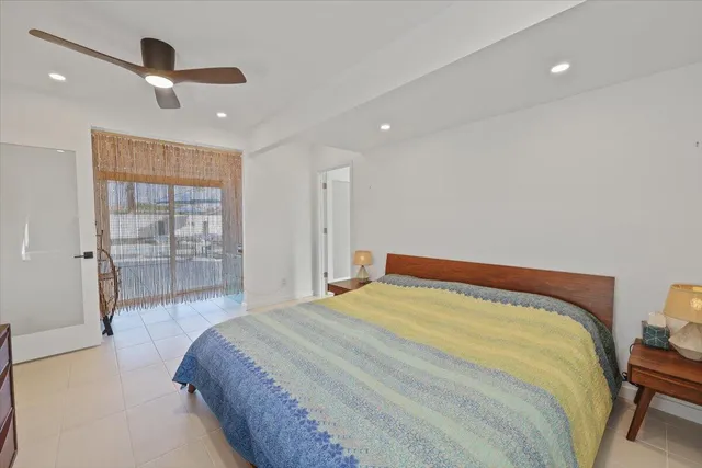 a bedroom with a bed and a dresser with the wooden floor