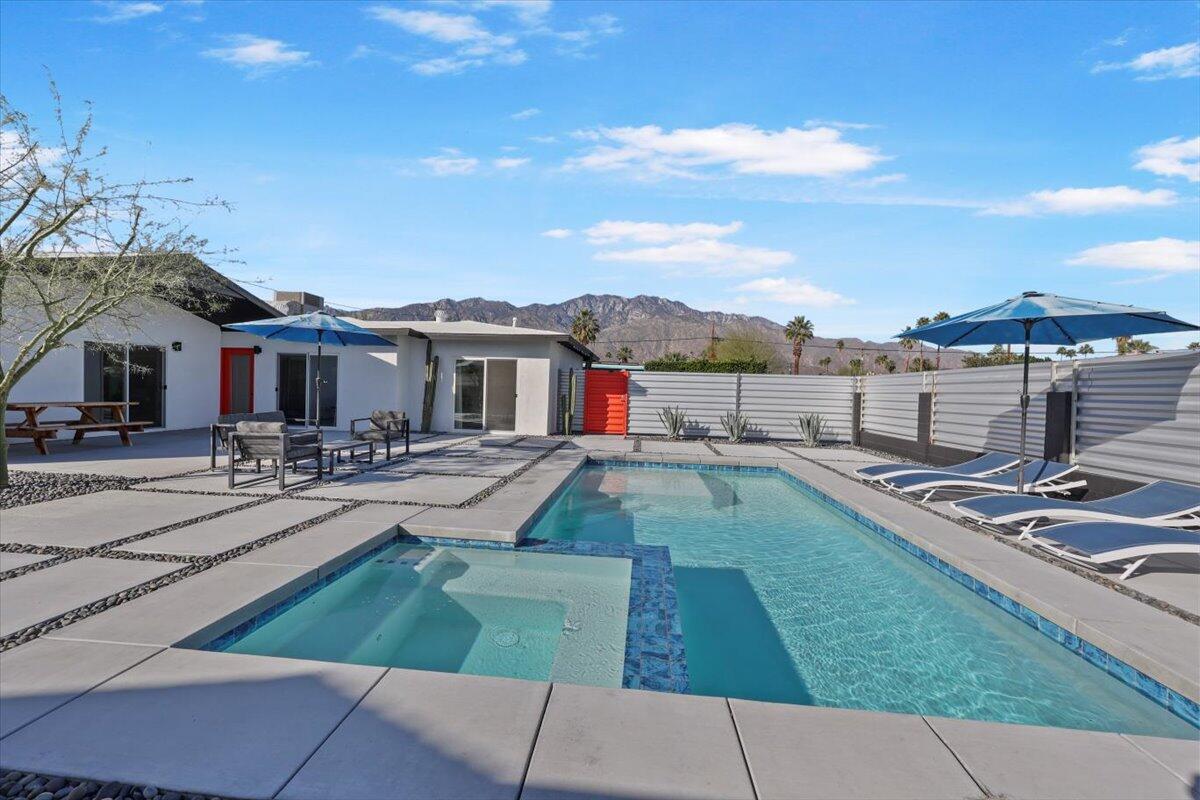 3991 Calle San Raphael Palm Springs, CA 92264 - Photo 3 of 45 a view of a patio with couches and table and chairs under an umbrella