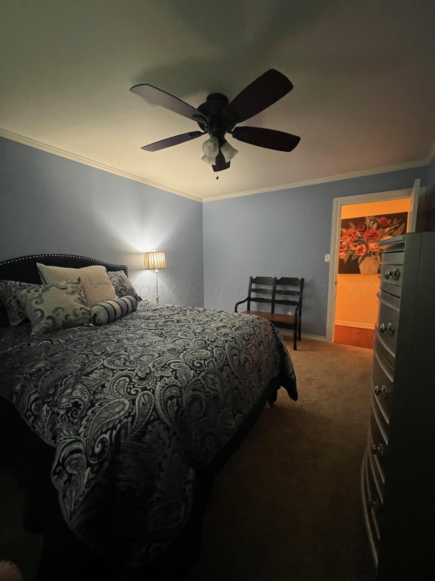6213 Dreyfuss Road Amarillo, TX 79106 - Photo 14 of 27 a bedroom with a bed and a chandelier
