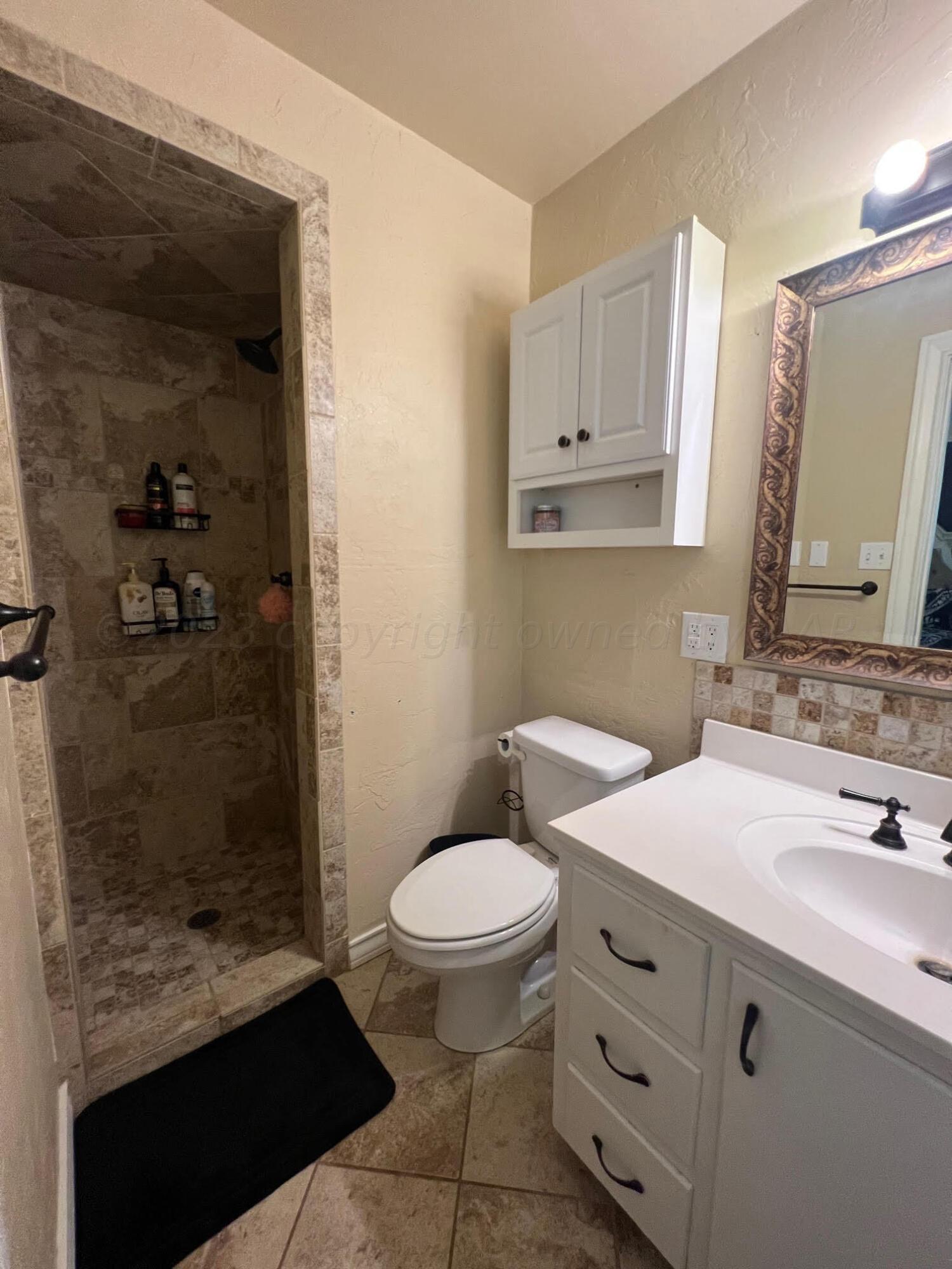 6213 Dreyfuss Road Amarillo, TX 79106 - Photo 19 of 27 a bathroom with a sink a toilet and shower