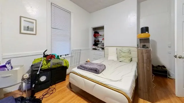 a bedroom with a bed and a wooden floor