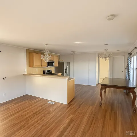 a view of kitchen with refrigerator microwave and wooden floor
