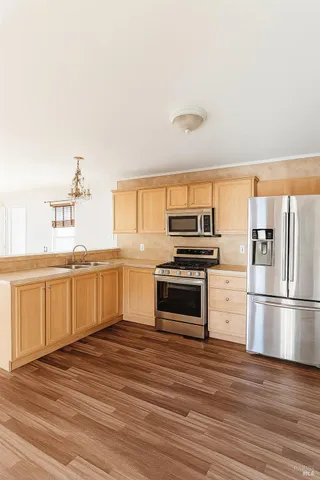 a kitchen with granite countertop a refrigerator and a stove top oven