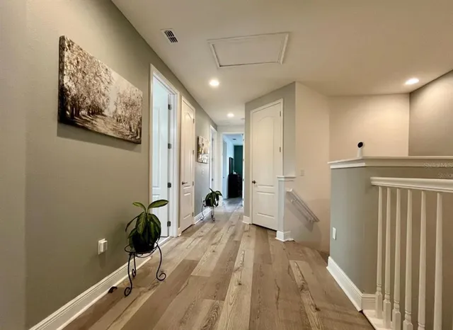 a view of a hallway with wooden floor and staircase