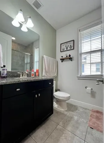 a bathroom with a toilet a sink and mirror