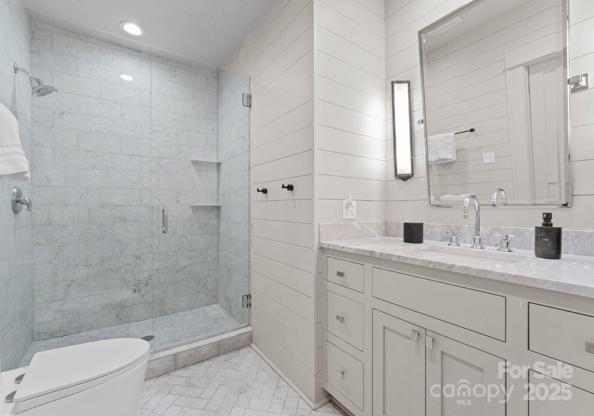 1550 Queens Road West Charlotte, NC 28207 - Photo 28 of 40 a bathroom with a double vanity sink toilet and shower