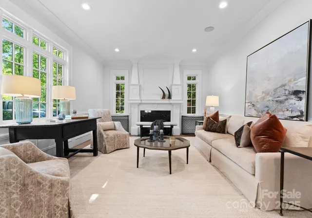 a living room with furniture a large window and a fireplace