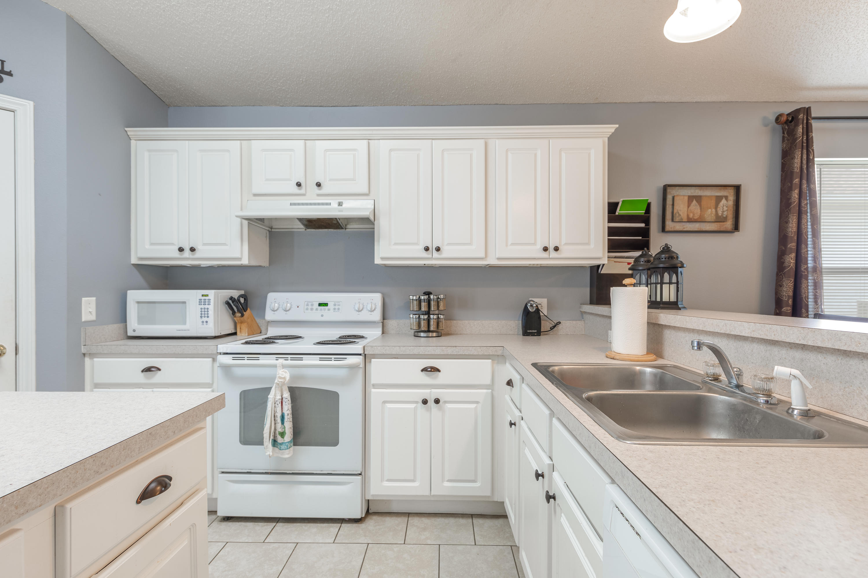 130 Sandstone Trail Crestview, FL 32539 - Photo 7 of 24 a kitchen with white cabinets white appliances sink and dishwasher