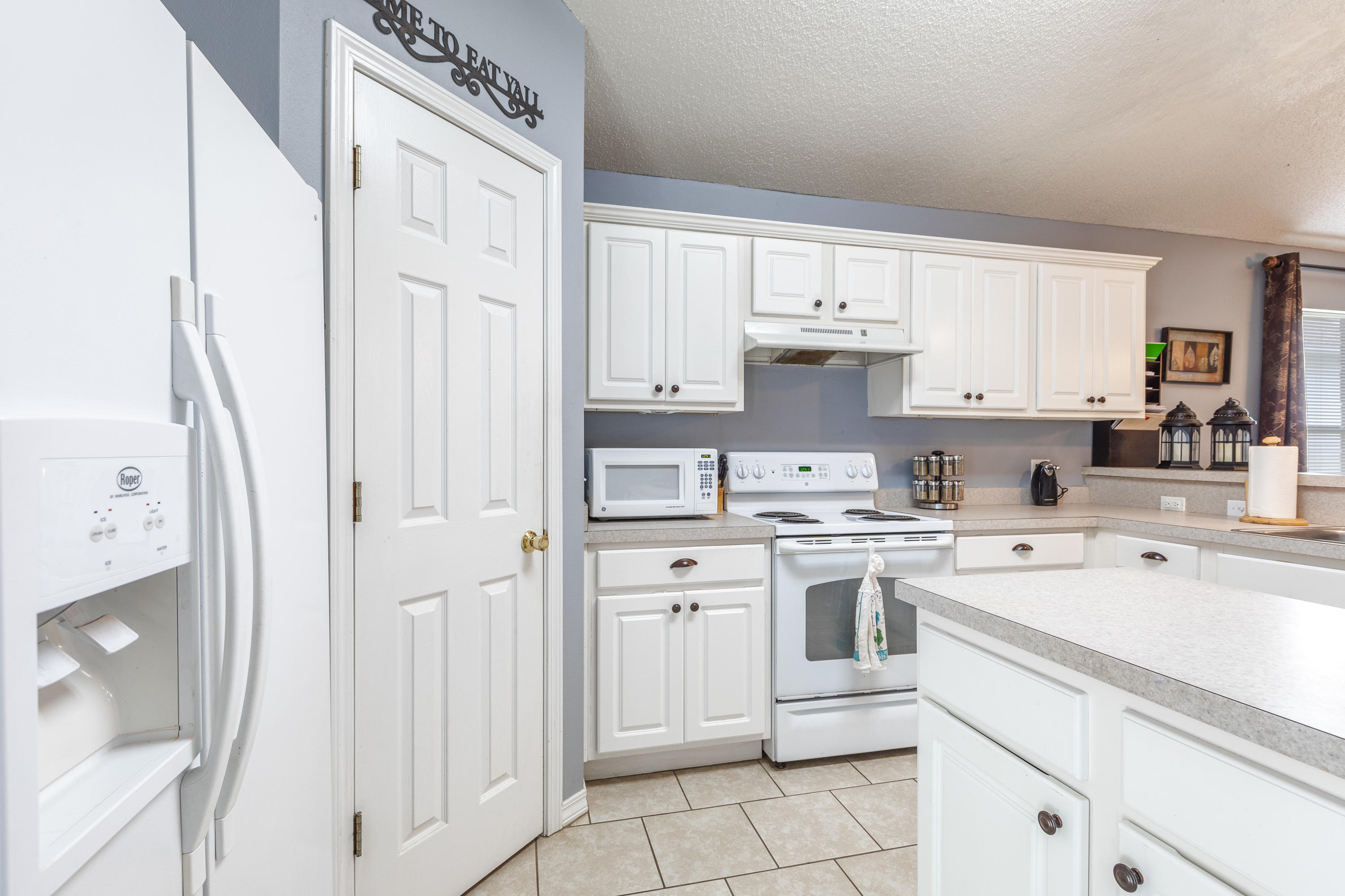 130 Sandstone Trail Crestview, FL 32539 - Photo 8 of 24 a kitchen with white cabinets and white appliances