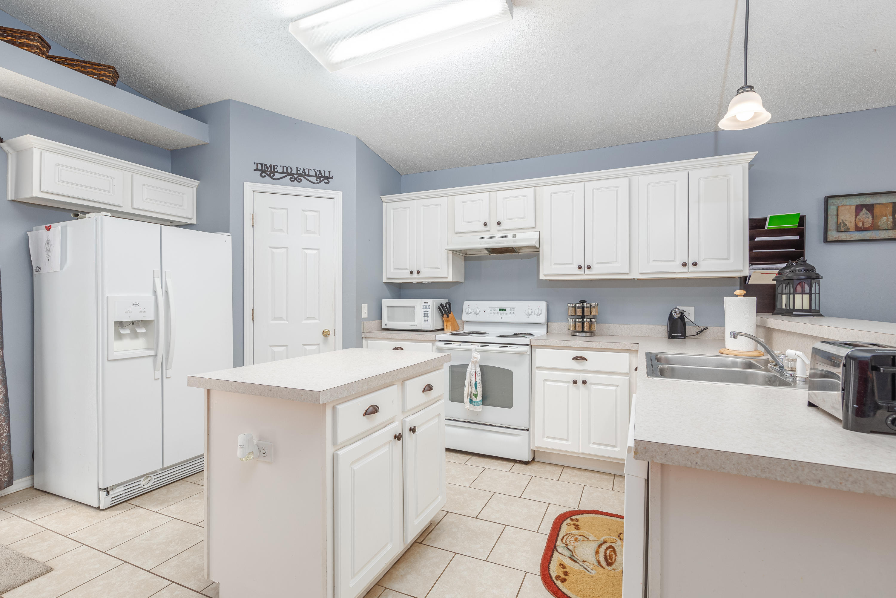 130 Sandstone Trail Crestview, FL 32539 - Photo 9 of 24 a kitchen with white cabinets and white appliances