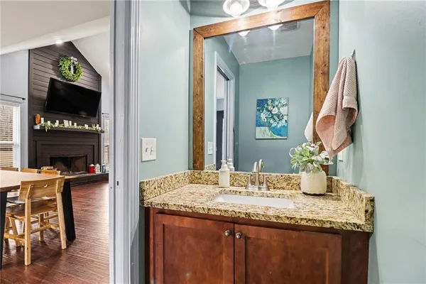 a bathroom with a granite countertop sink and a mirror