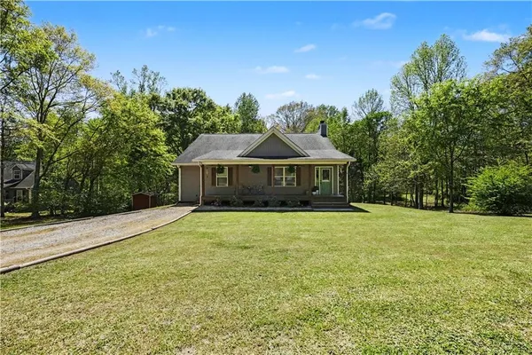 a front view of a house with yard and green space