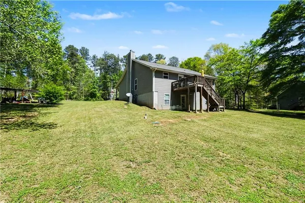 a view of a house with backyard and trees