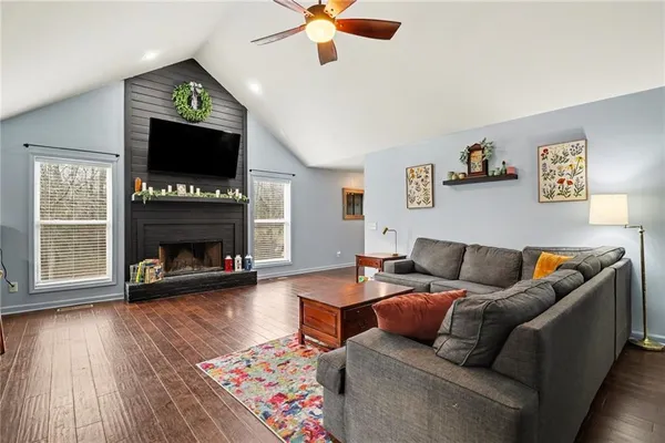 a living room with furniture a flat screen tv and a fireplace