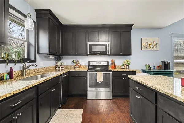 a kitchen with a sink stove top oven and microwave