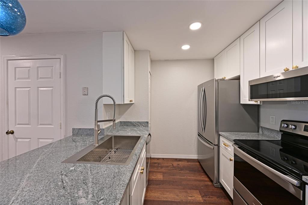 8809 Manor Loop, Unit 106 Lakewood Ranch, FL 34202 - Photo 15 of 40 a kitchen with stainless steel appliances granite countertop a sink stove and refrigerator