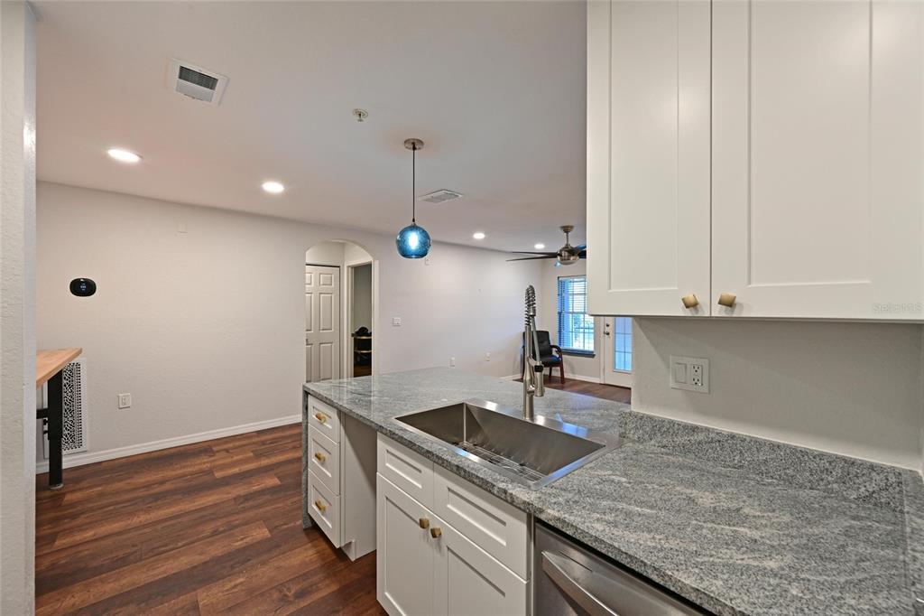 8809 Manor Loop, Unit 106 Lakewood Ranch, FL 34202 - Photo 16 of 40 a kitchen that has a sink and a stove with wooden floor