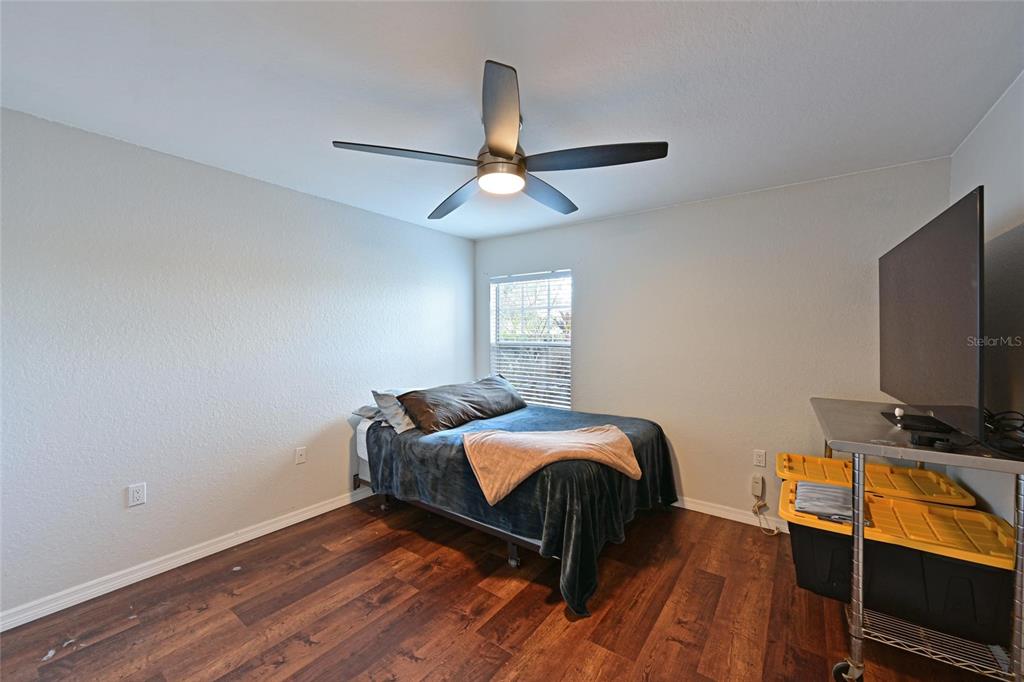 8809 Manor Loop, Unit 106 Lakewood Ranch, FL 34202 - Photo 23 of 40 a bedroom with bed and a chandelier