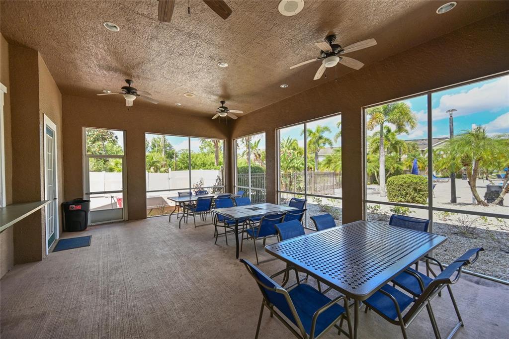 8809 Manor Loop, Unit 106 Lakewood Ranch, FL 34202 - Photo 33 of 40 a view of a dining room with furniture large windows and wooden floor