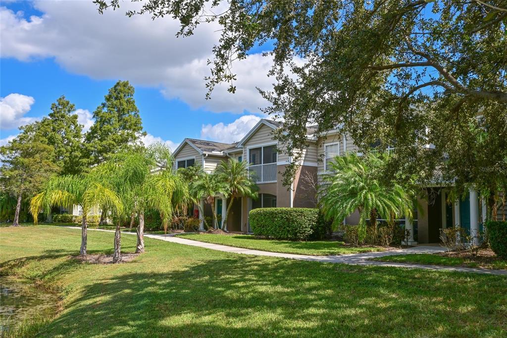 8809 Manor Loop, Unit 106 Lakewood Ranch, FL 34202 - Photo 8 of 40 a garden with trees in front of it