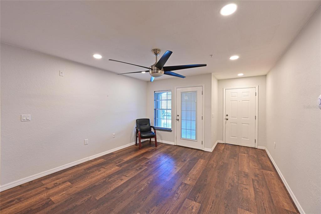 8809 Manor Loop, Unit 106 Lakewood Ranch, FL 34202 - Photo 9 of 40 a view of empty room with wooden floor and fan