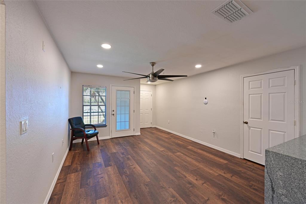 8809 Manor Loop, Unit 106 Lakewood Ranch, FL 34202 - Photo 10 of 40 an empty room with wooden floor and windows