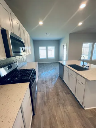 a kitchen with stainless steel appliances granite countertop wooden cabinets and a stove top oven